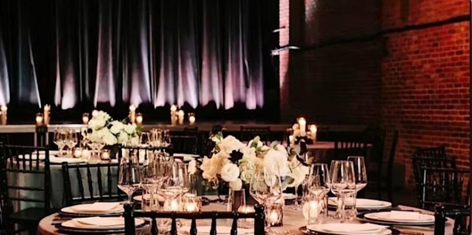 Elegant candlelit wedding reception setup with black chairs, white florals, and soft draping at The House of Independents, promoting an upcoming bridal expo.