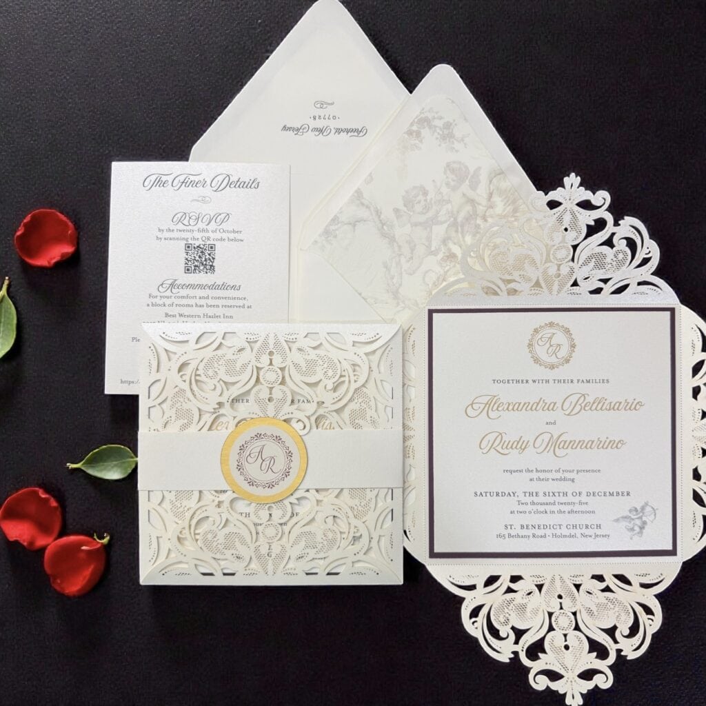 Luxury laser-cut wedding invitation suite with monogram details, RSVP card, envelopes, and decorative floral elements created by Tina Conway Designs.