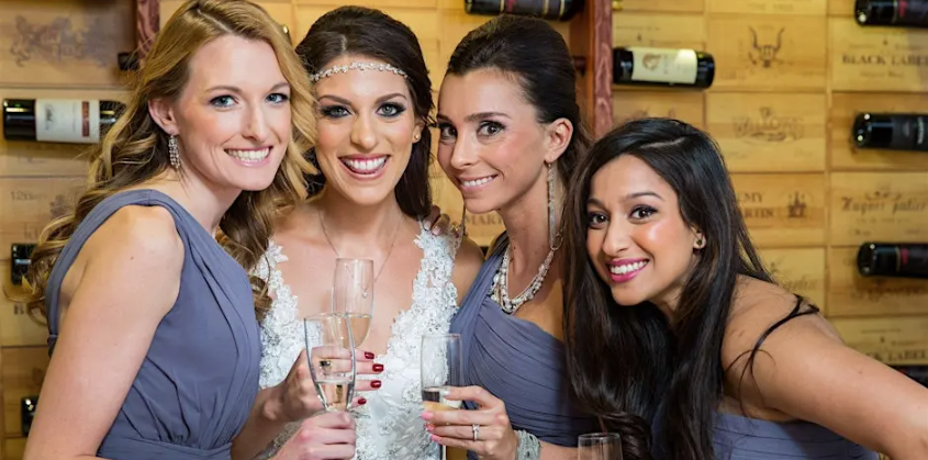 Bride and bridesmaids holding champagne glasses at a wedding showcase event at The Wilshire Grand in West Orange NJ